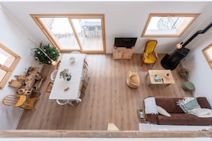 A spacious living area with a dining table, sofa, and a fireplace.