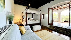A bedroom with a four-poster bed, a sofa, a potted plant, and a view of an outdoor balcony. - Villa 'Ses Casetes Ibiza' with Mountain View, Wi-Fi and Air Conditioning (Illes Balears)