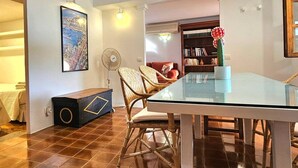 A dining area with a glass table, wicker chairs, a bookshelf, and a map on the wall. - Villa 'Ses Casetes Ibiza' with Mountain View, Wi-Fi and Air Conditioning (Illes Balears)
