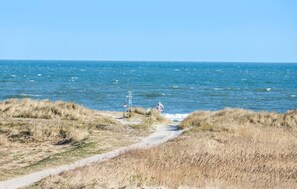 A coastal path leading to the sea with a lifebuoy and a sign indicating a beach. - 3 bedroom beautiful home in Grenaa (Grenaa)