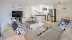 A modern living room with a sofa, TV, and a small dining table.