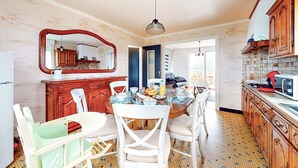 A dining area with a round table, white chairs, and a large mirror above the counter. - 3 bedroom nice home in Arzal (Arzal)