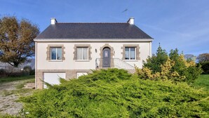 A two-story house with a grey roof, stone window frames, and a front entrance with a small porch. - 3 bedroom nice home in Arzal (Arzal)