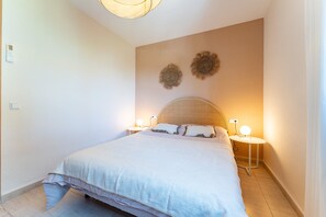 A bedroom with a bed, bedside lamps, and wall decor. - Holiday Home 'Feliz' with Sea View, Wi-Fi and Air Conditioning (Benalmadena)