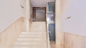 Un escalier menant à une pièce équipée d’un mini-bar et d’une porte sur laquelle figure un panneau de sécurité.