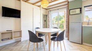 Eine moderne Küche mit Einbau-Mikrowelle, Kühlschrank und Essbereich mit rundem Tisch und vier Stühlen.