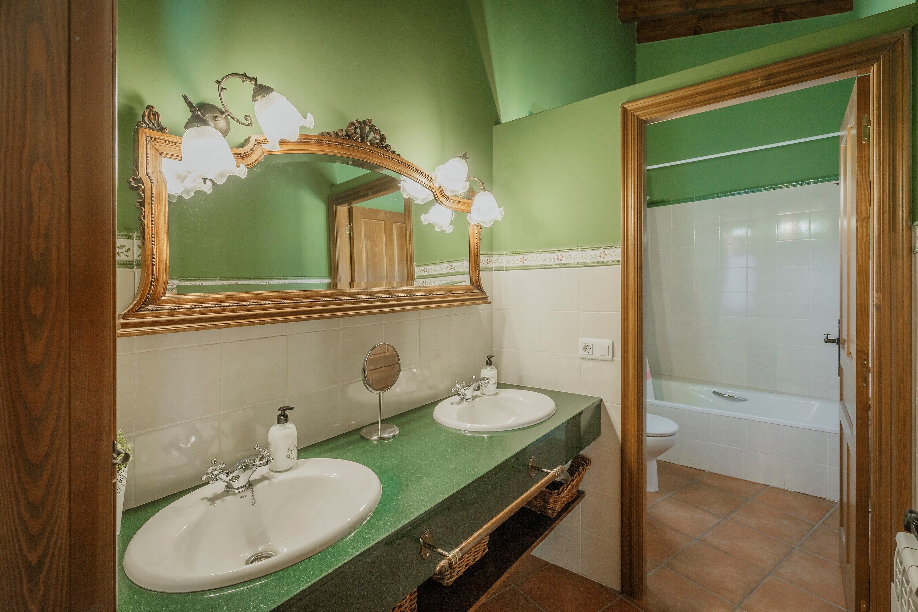 A bathroom with two sinks, a mirror, and a shower.