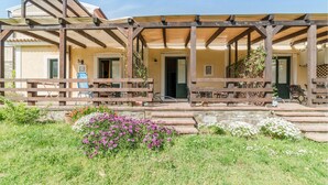 A covered outdoor seating area with wooden benches and a pergola structure.