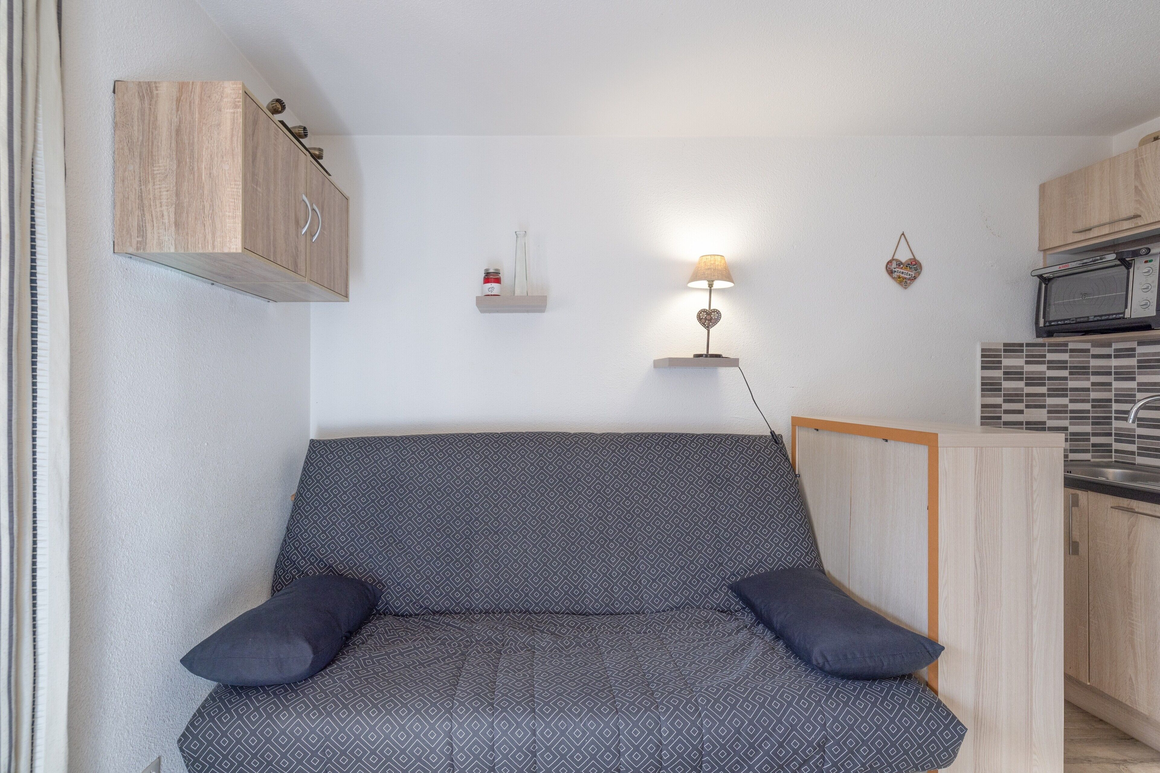 A compact kitchenette with a microwave, a small oven, and a sink.