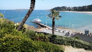 A coastal view with a marina, boats, and a beach. - "Ti Roz" 3-star Apartment with Sea View, Direct Beach Access and GR34 (Perros-Guirec)