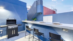 A rooftop bar with a grill, bar stools, and a small plant. - Vacation Home 'Magma' with Private Terrace, Private Garden and Wi-Fi (Santa Brígida)
