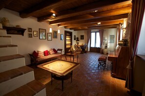 Un salon chaleureux avec une table en bois, un canapé et un escalier.