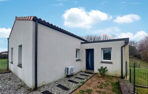 Simple, single-story building with a flat roof and functional design, featuring a small window and door.