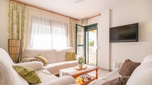 Una sala de estar con un sofá, una mesa de centro y un televisor.