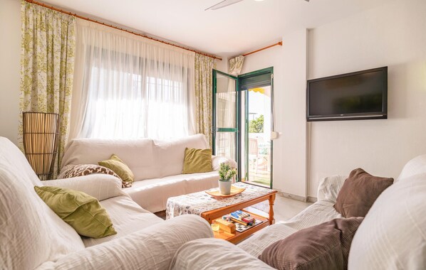A living room with a sofa, a coffee table, and a television.