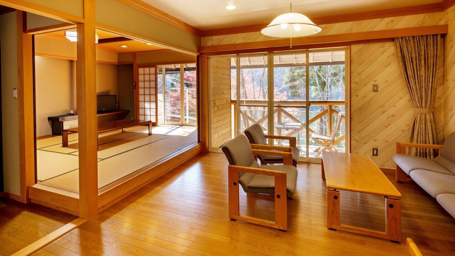 A traditional Japanese-style room with tatami flooring, a low wooden table, and a sofa.