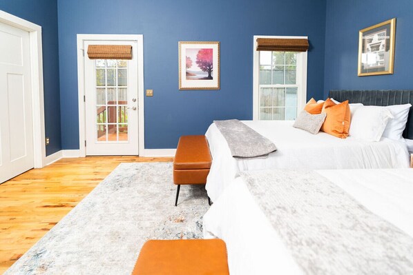 A bedroom with a bed, two bedside tables, a bench, and a door.