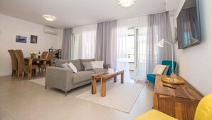 Una sala de estar moderna con un sofá, una mesa de centro y un comedor con sillas y una mesa.