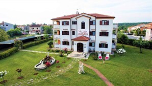 Villa Linct Apartments with a central entrance, a garden with a fountain, and a view of the surrounding neighborhood. - Holiday apartment in a beautiful setting, with air conditioning (Funtana)