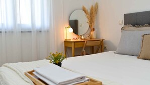 A neatly arranged bedroom with a bed, bedside table, desk, and a mirror. - Holiday apartment with air conditioning (Pula)