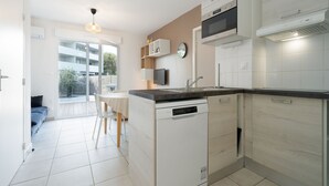 A modern kitchen with white cabinetry, a built-in oven, and a dishwasher.