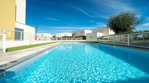 Swimmers can enjoy the pool surrounded by a low fence.