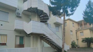 A multi-story building with a spiral staircase leading to the upper floors. - Studio mit Klimaanlage (Bibione)