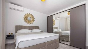 Una camera da letto con un letto, comodini, un armadio e uno specchio.