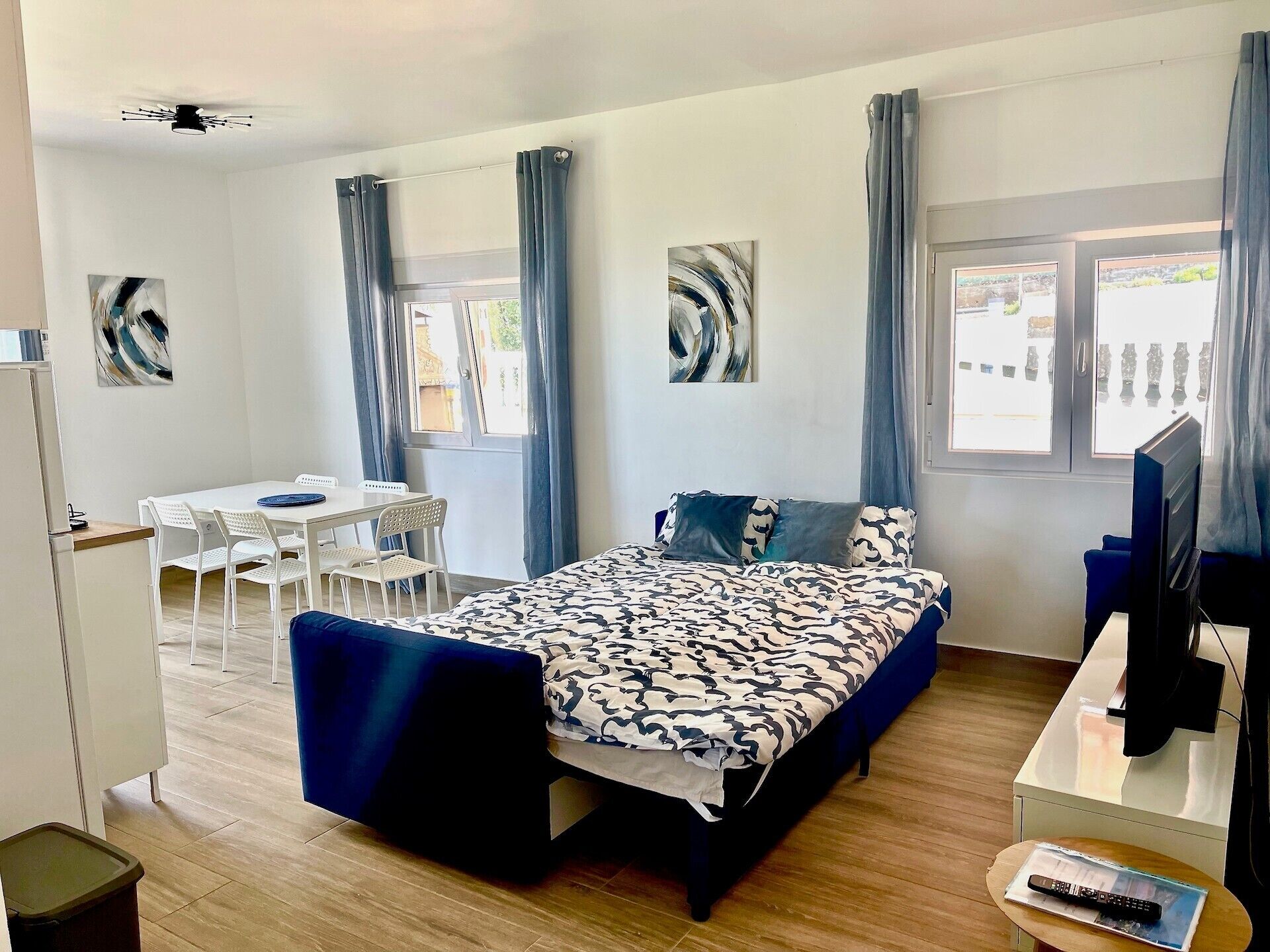 Una habitación de hotel con cama, escritorio, silla, televisión y ventana.