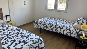 A bedroom with two beds, a desk, a chair, a window, and a wardrobe. - Sea View Apt4 Finca TenDays Orotava with Sea View, Wi-Fi and Air Conditioning (La Orotava)