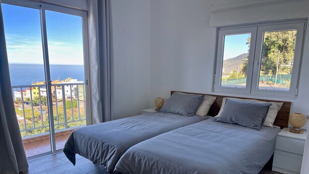 A bedroom with two beds, a balcony, and a view of the sea. - Sea View Apt4 Finca TenDays Orotava with Sea View, Wi-Fi and Air Conditioning (La Orotava)