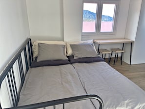 A single bed with a metal frame, a desk with two chairs, and a window with a mountain view. - Holiday Studio 'Finca Ten Days - El Teide' with Sea View, Wi-Fi and Air Conditioning (La Orotava)