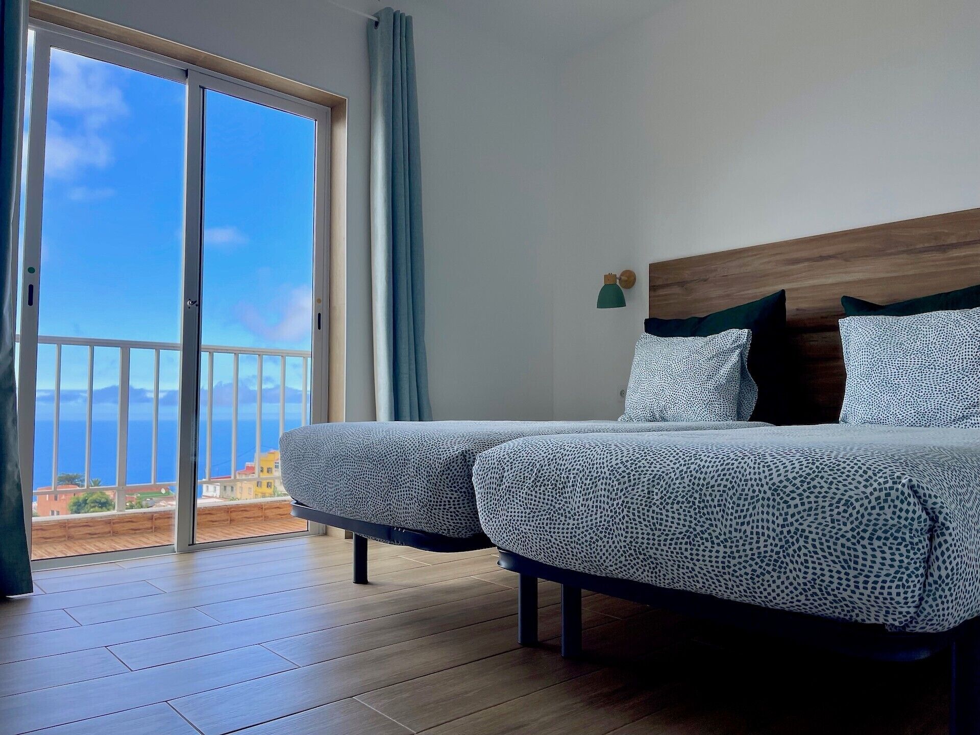 Un dormitorio con un amplio ventanal corredera que da a un balcón con vistas al mar.