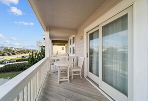 Enjoy the view from this balcony with a table and chairs, perfect for taking in the sights of the surrounding neighborhood.