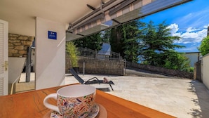 Una taza sobre una mesa con vista a un muro de piedra y una reja de metal al fondo.