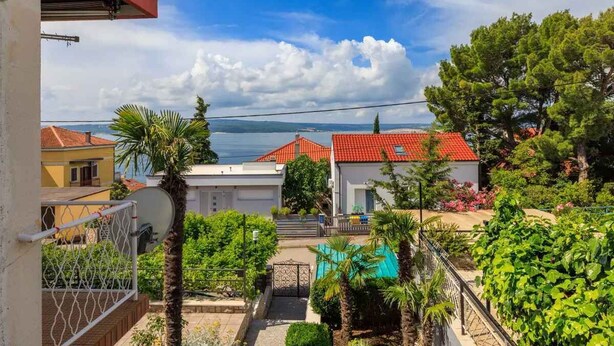 A residential area with houses, a swimming pool, and a view of the sea.
