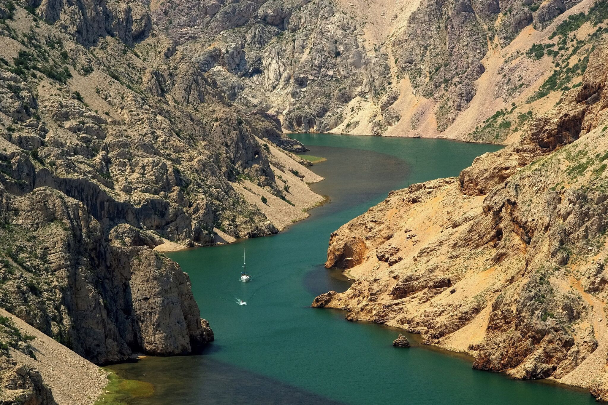 A river winding through a rocky canyon with sparse vegetation.
