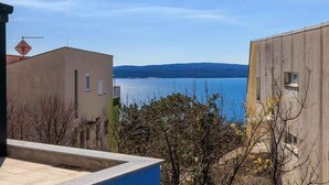 Un edificio residencial con vista a un lago y colinas lejanas.