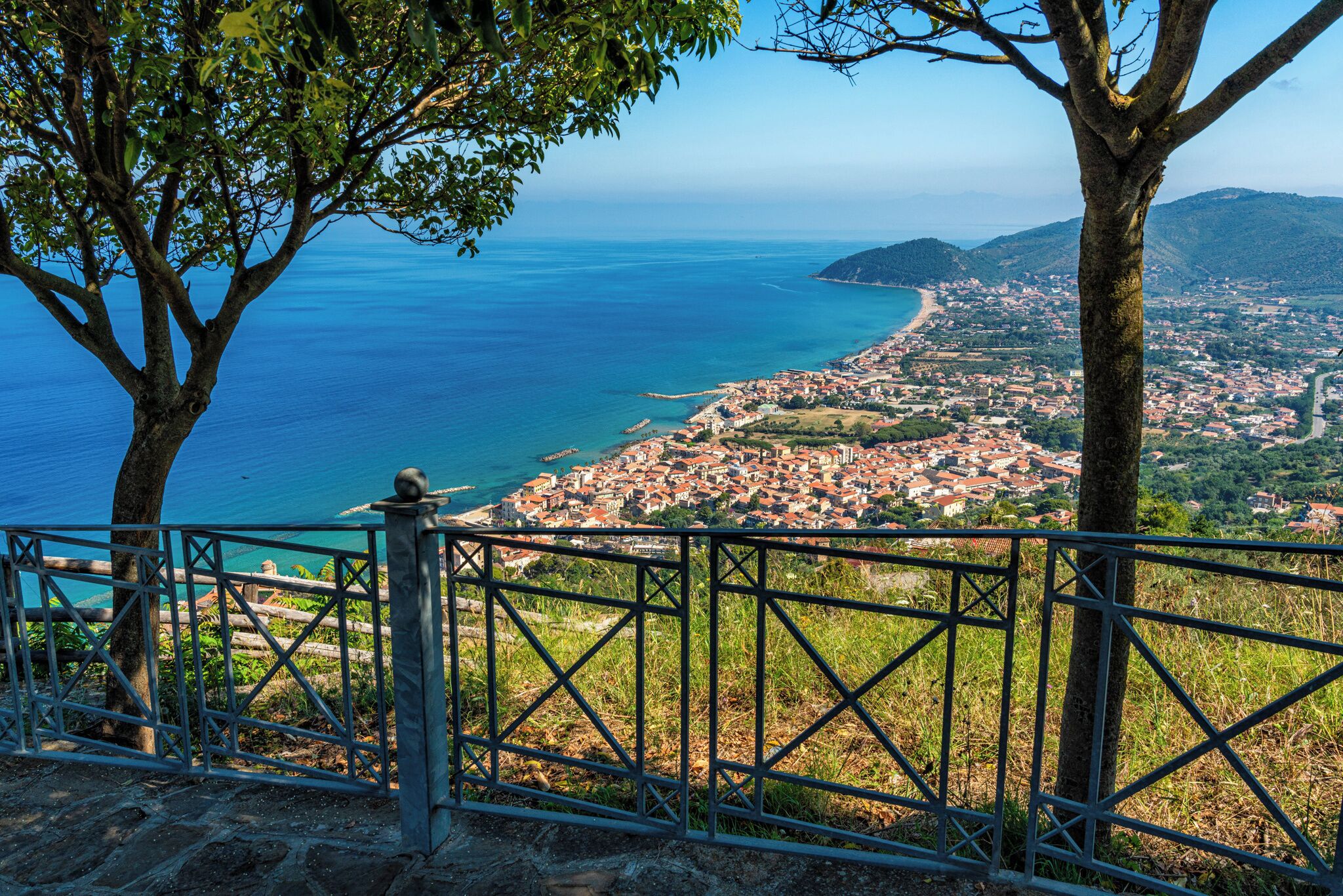 A coastal town with a view of the sea and mountains.