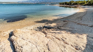 A rocky shoreline with clear water and distant mountains. - Holiday home with air conditioning and pool (Novigrad)