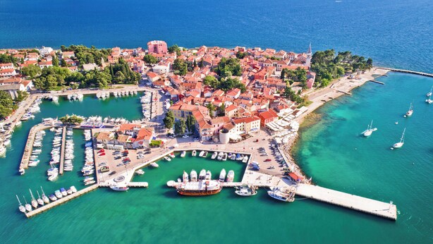 An aerial view of a coastal town with a marina, boats, and a prominent church. - Holiday home with air conditioning and pool (Novigrad)