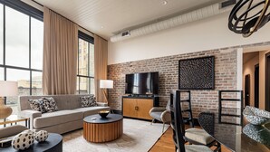 A modern living room with a sofa, coffee table, and dining area.