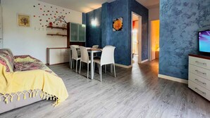 Ein modernes Schlafzimmer mit Bett, einer Essecke mit Stühlen und einem Fernseher.