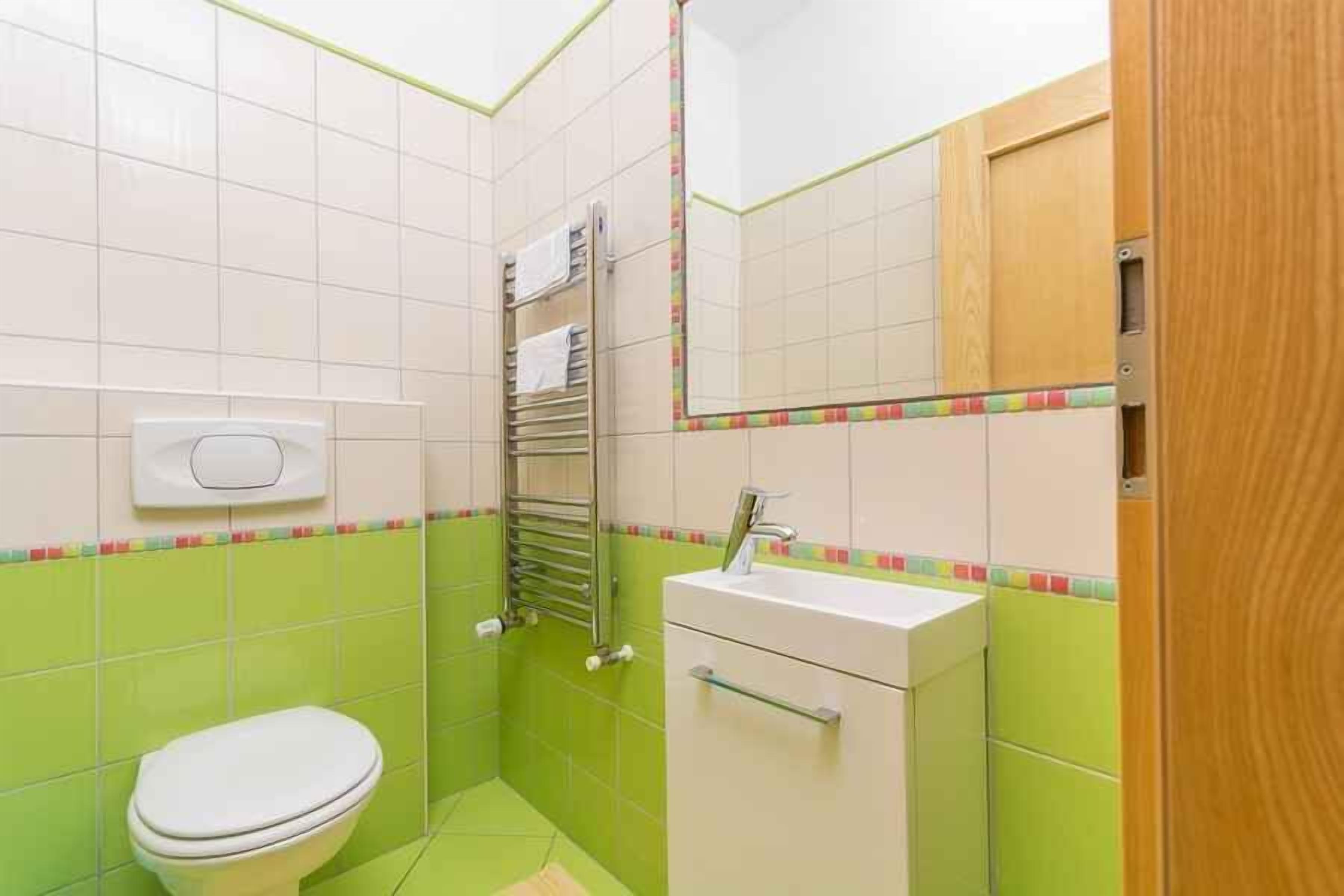 A small bathroom with a toilet, sink, and towel rack.
