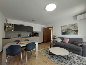 Um espaço compacto com cozinha compacta, área de refeições e sofá.