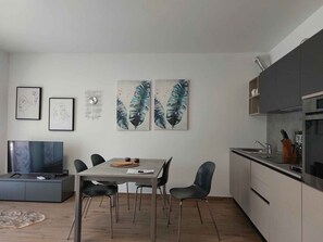 Cozinha moderna com mesa de jantar, cadeiras e obras de arte nas paredes.
