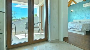 A modern bedroom with a bed, a balcony with chairs, and a view of the sky. - Villa with air conditioning and pool (Nova Vas/Novigrad)