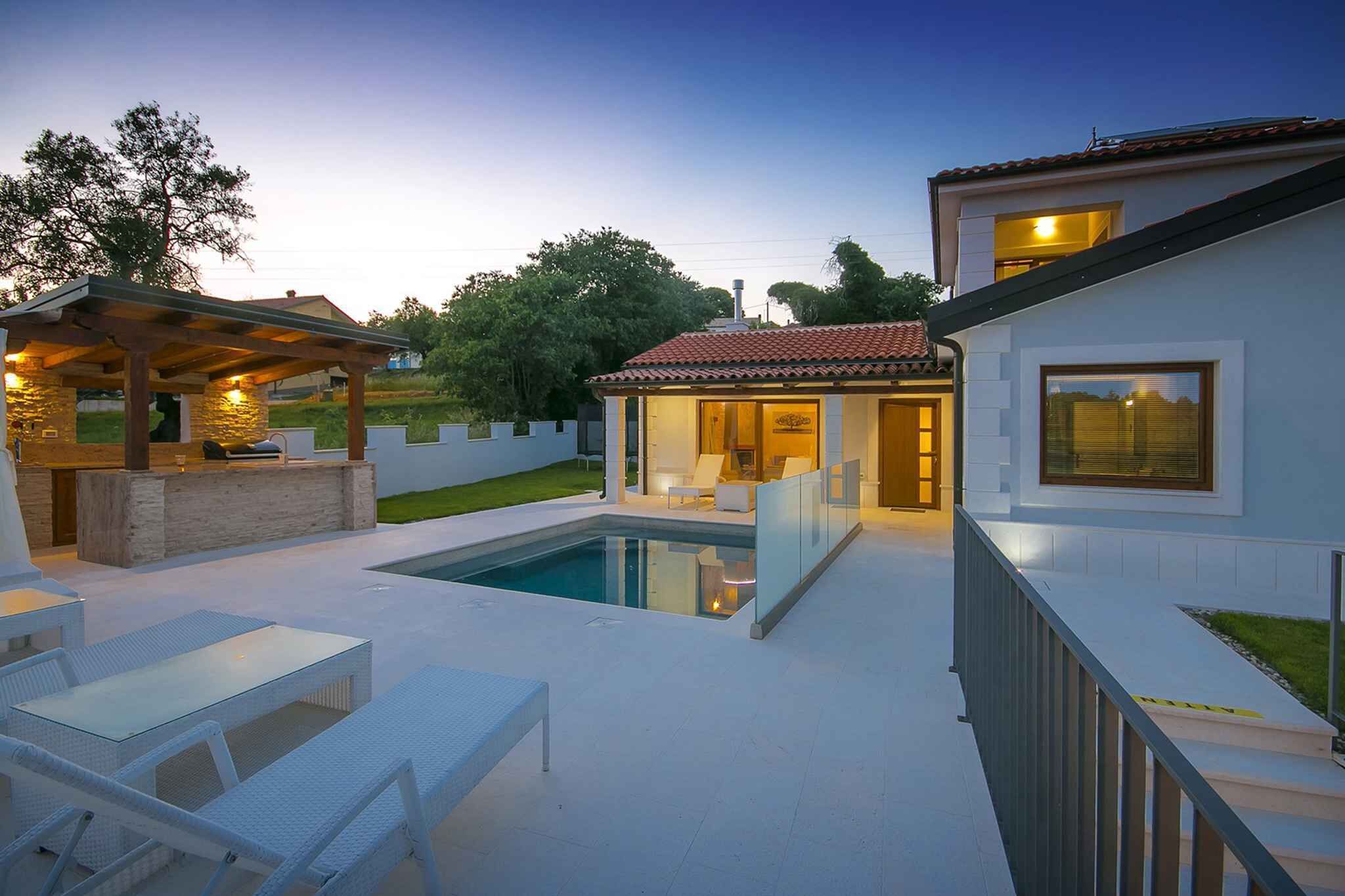 A modern outdoor pool area with a pergola, lounge chairs, and a bar.