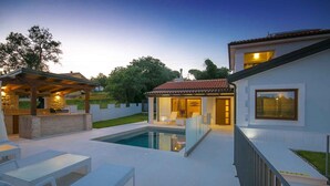 A modern outdoor pool area with a pergola, lounge chairs, and a bar. - Villa with air conditioning and pool (Nova Vas/Novigrad)