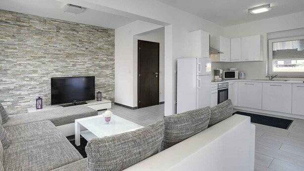 Un salon moderne avec un téléviseur à écran plat, un canapé et une table basse.